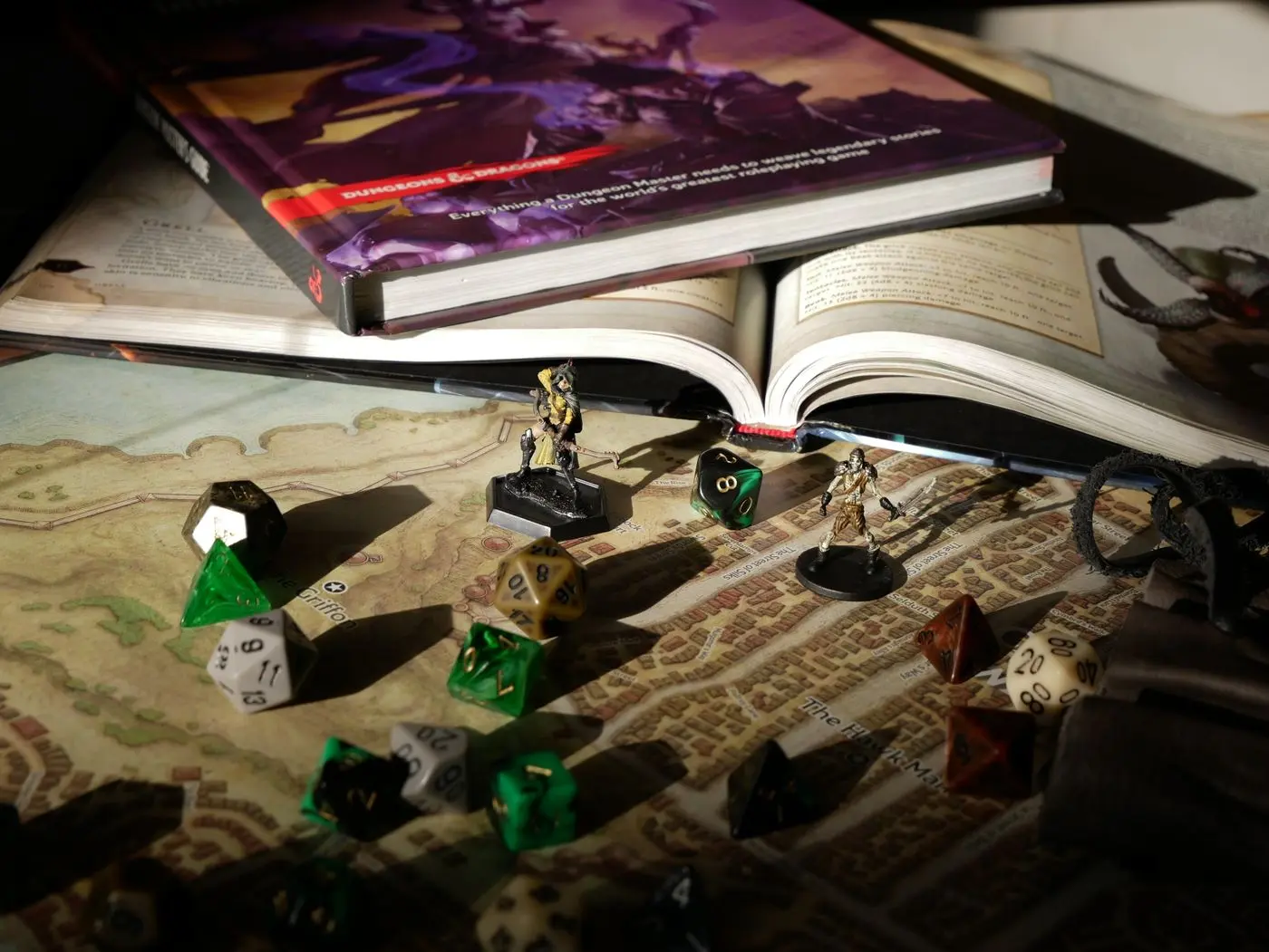 Figurines, dés et livres disposés pour une partie de jeu de rôle