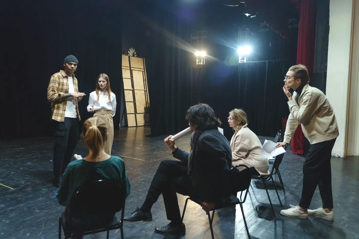 Comédiens adultes répétant une scène de théâtre sous la direction d’un intervenant
